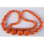 AN AMBER NECKLACE. Length 70cm, largest bead 21.1mm, weight 89g