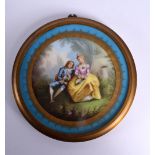A 19TH CENTURY FRENCH SEVRES PORCELAIN PLAQUE painted with lovers in landscapes. 16 cm diameter.