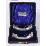 A CASED PAIR OF EDWARDIAN SILVER BOAT SHAPED SALTS WITH BLUE GLASS LINERS. Hallmarked Birmingham 1