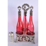 A LARGE SILVER PLATED RUBY GLASS TRIPLE DECANTER SET. 44 cm high.