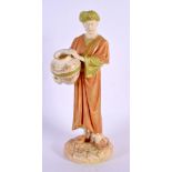 A ROYAL WORCESTER PORCELAIN FIGURE OF AN EASTERN MALE modelled holding a vase. 22 cm high.