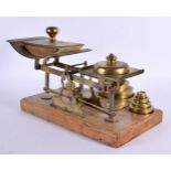 A LOVELY SET OF VICTORIAN OAK AND BRASS POSTAL SCALES with original weights. 34 cm x 24 cm.