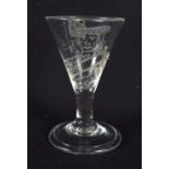 AN ANTIQUE ENGRAVED WINE GLASS dated 1745. 9 cm high.