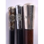 TWO ANTIQUE MILITARY SWAGGER STICKS together with another silver mounted stick. Largest 90 cm long.