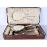 A CASED EDWARDIAN SILVER PLATED TORTOISESHELL CASED DRESSING TABLE SET. Largest 25 cm long. (5)