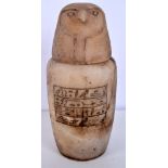 An Egyptian carved stone jar with an eagle headed lid 26 cm.