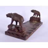 A LATE 19TH CENTURY BAVARIAN BLACK FOREST SLIDING WOOD BOOK RACK formed as standing bears. 44 cm lon