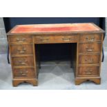 A 20th Century 9 drawer desk with leather inlaid top 77 x 122 x 61 cm