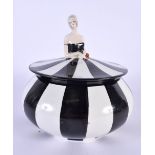 A RARE ART DECO CARLTONWARE POWDER BOX AND COVER formed as a female wearing a black and white dress.