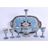 AN ISLAMIC MIDDLE EASTERN ENAMELLED EWER ON STAND with matching goblets. Largest 25 cm high. (7)