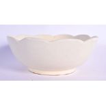 A CHINESE QING DYNASTY DING STYLE CREAM GLAZED BOWL elegantly modelled with a lotus type flower inte