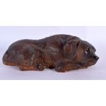 A 19TH CENTURY BAVARIAN BLACK FOREST FIGURE OF A SLEEPING HOUND modelled recumbent 22 cm x 10 cm.