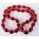 A STRING OF CHERRY COLOURED BEADS. 46cm long, Largest bead 17.8mm