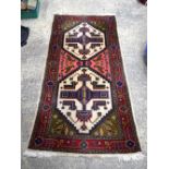 A Persian wool rug 190 x 89 cm.