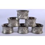 A SET OF SIX 19TH CENTURY JAPANESE MEIJI PERIOD WHITE METAL NAPKIN RINGS decorated with dragons. 386