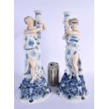 A LARGE PAIR OF LATE 19TH CENTURY GERMAN PORCELAIN CANDLESTICKS formed as figures holding aloft