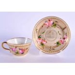 A FRENCH SEVRES PORCELAIN TEACUP AND SAUCER painted with roses. 10.5 cm diameter. (2)