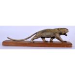 A 19TH CENTURY MIDDLE EASTERN CARVED RHINOCEROS HORN FIGURE OF A ROAMING LIONESS upon a wooden