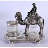 AN UNUSUAL EARLY 20TH CENTURY SILVER PLATED DESK STAND formed as a male upon a camel. 801 grams