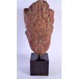 A 16TH/17TH CENTURY SOUTH EAST ASIAN CARVED RED STONE HEAD of buddhistic form. 28 cm x 10 cm.