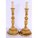 A FINE PAIR OF EARLY 19TH CENTURY FRENCH EMPIRE ORMOLU CANDLESTICKS formed as nubian fawn draped