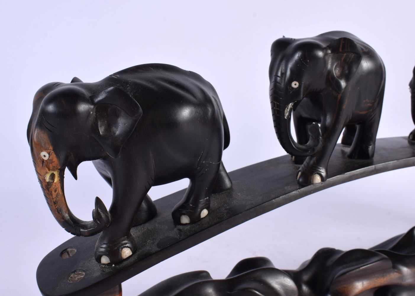 A LATE 19TH CENTURY ANGLO INDIAN CARVED HARDWOOD ELEPHANT GROUP modelled roaming. 45 cm x 20 cm. - Image 2 of 5