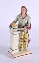 A LATE 18TH/19TH CENTURY ENGLISH POTTERY FIGURE OF A FEMALE modelled beside a column. 15 cm high.