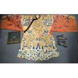 A LARGE 19TH CENTURY CHINESE ORANGE SILK WORK EMBROIDERED DRAGON ROBE together with a rank badge and