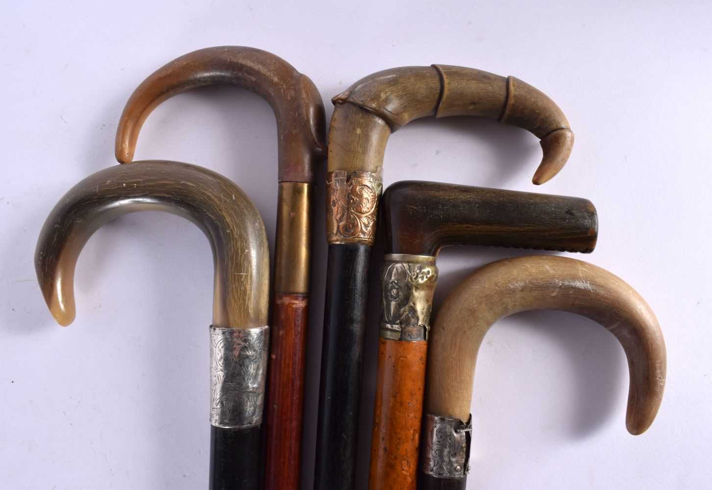 A GROUP OF FIVE 19TH CENTURY MIDDLE EASTERN CARVED RHINOCEROS HORN CANES two with silver mounts.