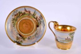 A 19TH CENTURY AUSTRIAN VIENNA PORCELAIN CUP AND SAUCER painted with landscapes. 13 cm diameter.