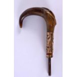 AN ANTIQUE CARVED RHINOCEROS HORN CANE HANDLE with yellow metal mounts. 20 cm x 10 cm.
