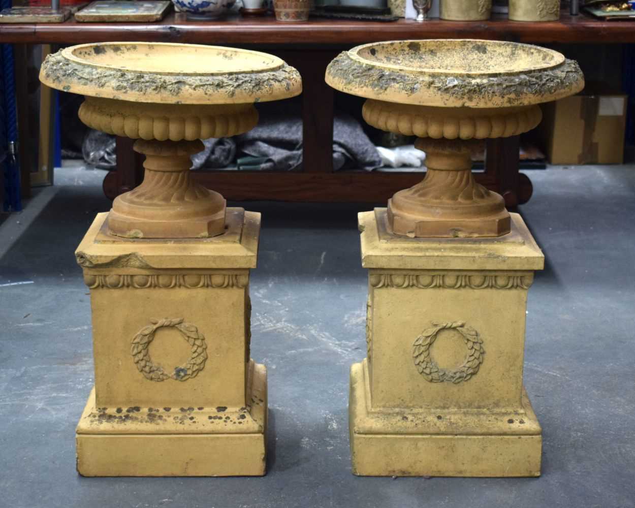 A GOOD PAIR OF 19TH CENTURY EUROPEAN TERRACOTTA URNS ON STANDS of classical form. 80 cm x 36 cm.