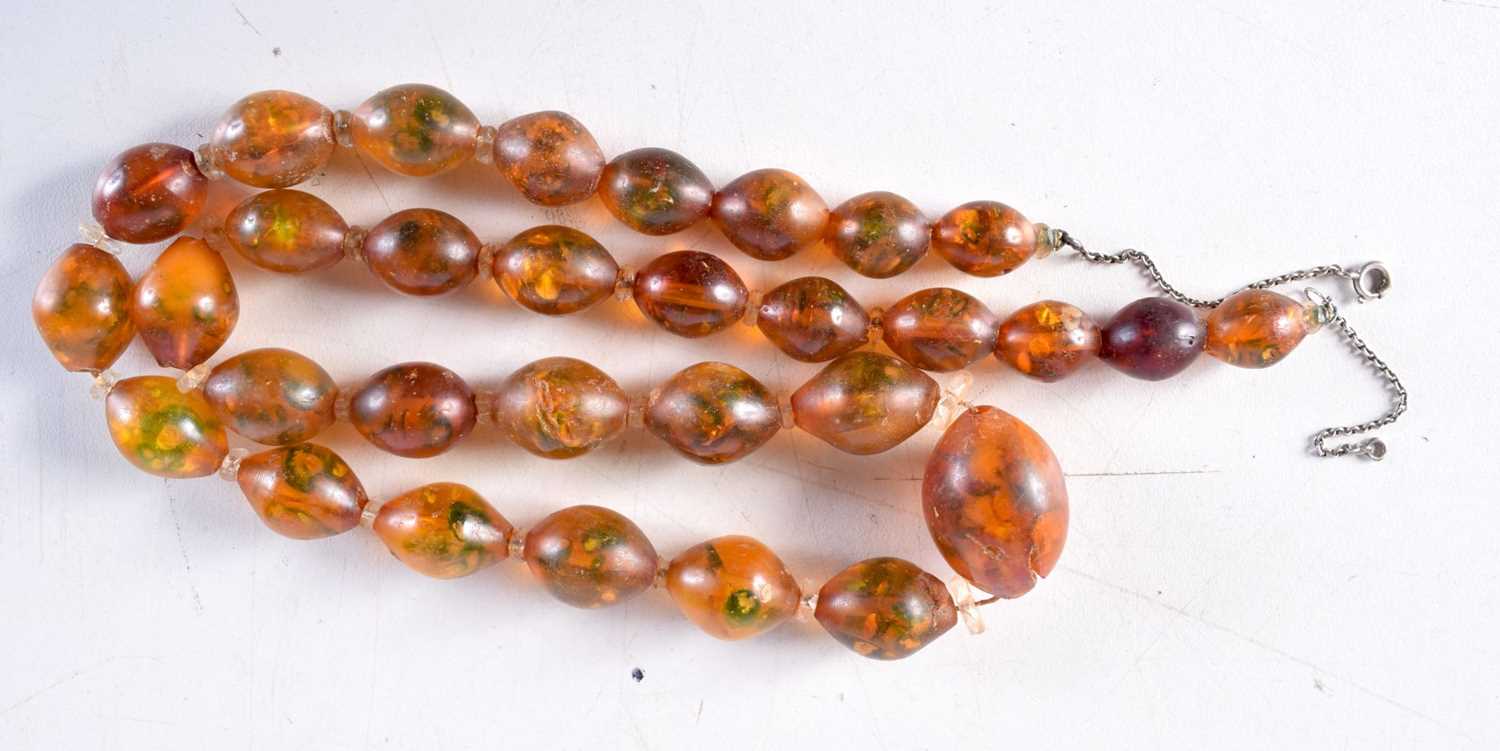 AN AMBER TYPE NECKLACE. 53 grams. 70 cm long, largest bead 3 cm x 2 cm.