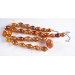 AN AMBER TYPE NECKLACE. 53 grams. 70 cm long, largest bead 3 cm x 2 cm.