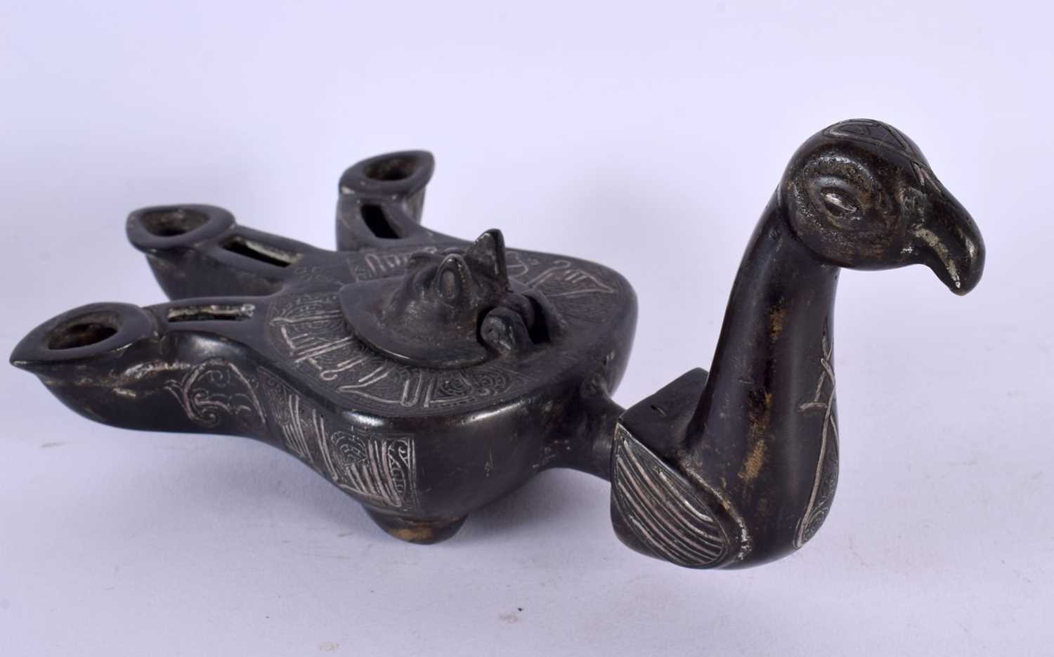 A 19TH CENTURY MIDDLE EASTERN SILVER INLAID BRONZE OIL LAMP formed as a bird, decorated with motifs. - Image 2 of 5