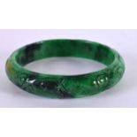 A CHINESE CARVED JADEITE BANGLE 20th Century. 7 cm diameter.