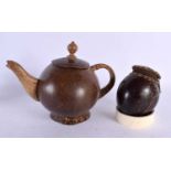 AN UNUSUAL TRIBAL CARVED COCONUT TEAPOT AND COVER together with a similar coconut purse. Largest