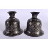 A PAIR OF 19TH CENTURY SILVER INLAID METAL CANDLE HOLDERS decorated with motifs. 10 cm x 6 cm.