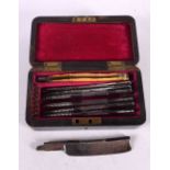 A CHARMING ANTIQUE CASED SET OF DAYS OF THE WEEK RAZORS within a hardwood case. 13 cm x 7 cm.