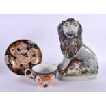 A LARGE EARLY 19TH CENTURY STAFFORDSHIRE FIGURE OF A LION together with an English cup and saucer.