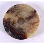 A 19TH CENTURY CHINESE CARVED TWO TONE JADE ROUNDEL Qing. 5 cm diameter.