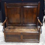 A large double panelled oak settle with blanket box 138 x 125 x 83 cm.