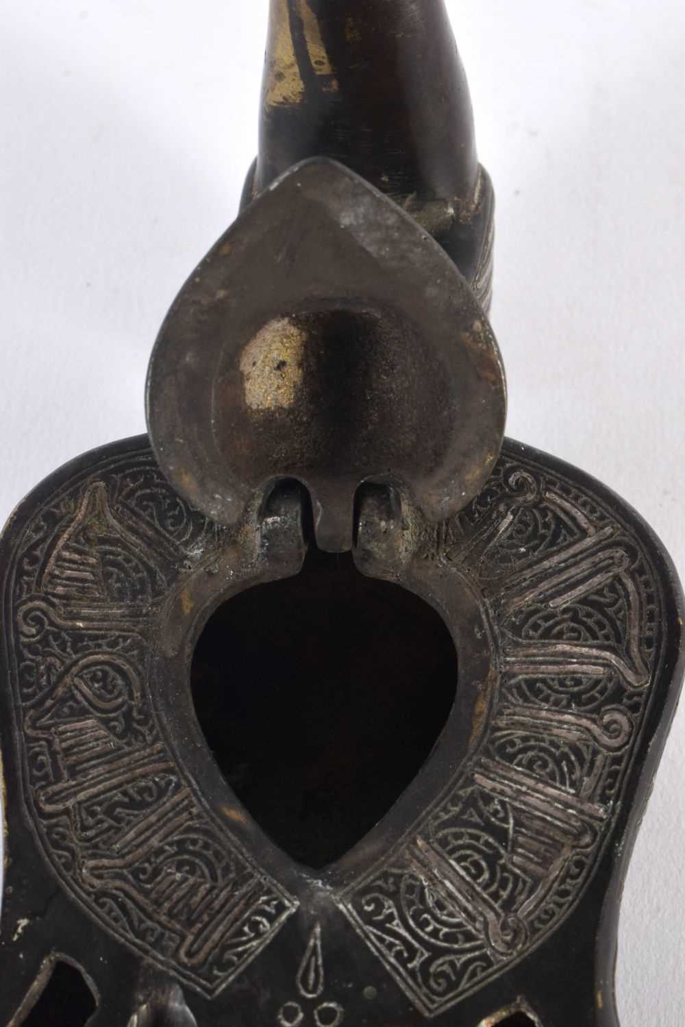 A 19TH CENTURY MIDDLE EASTERN SILVER INLAID BRONZE OIL LAMP formed as a bird, decorated with motifs. - Image 4 of 5