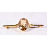 A 9CT GOLD YELLOW STONE BROOCH. 7.7 grams. 6.25 cm wide.