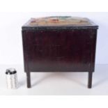 An antique wooden Ottoman with hinged lid and a woolwork upholstered seat 40 x 40 x 34 cm.