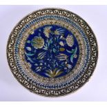 A 19TH CENTURY MIDDLE EASTERN FAIENCE TIN GLAZED IZNIK DISH painted with flowers and motifs. 26 cm