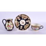 Royal Worcester teacup and saucer and matching cream jug painted with exotic birds in gilt panel