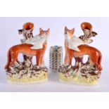 A LARGE PAIR OF 19TH CENTURY STAFFORDSHIRE FIGURES OF FOXES modelled holding game birds. 26 cm x