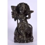 A LATE 19TH CENTURY INDIAN CARVED STONE FIGURE OF A BUDDHA modelled playing a pipe. 16 cm x 9 cm.