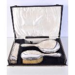 A CASED SILVER DRESSING TABLE SET. Birmingham 1923. 571 grams overall. Largest 26.5 cm x 14.5 cm. (